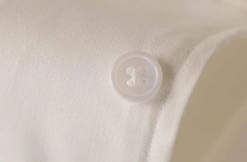 Close-up of Antonios washed tuxedo shirt button detail, stylish office wear.