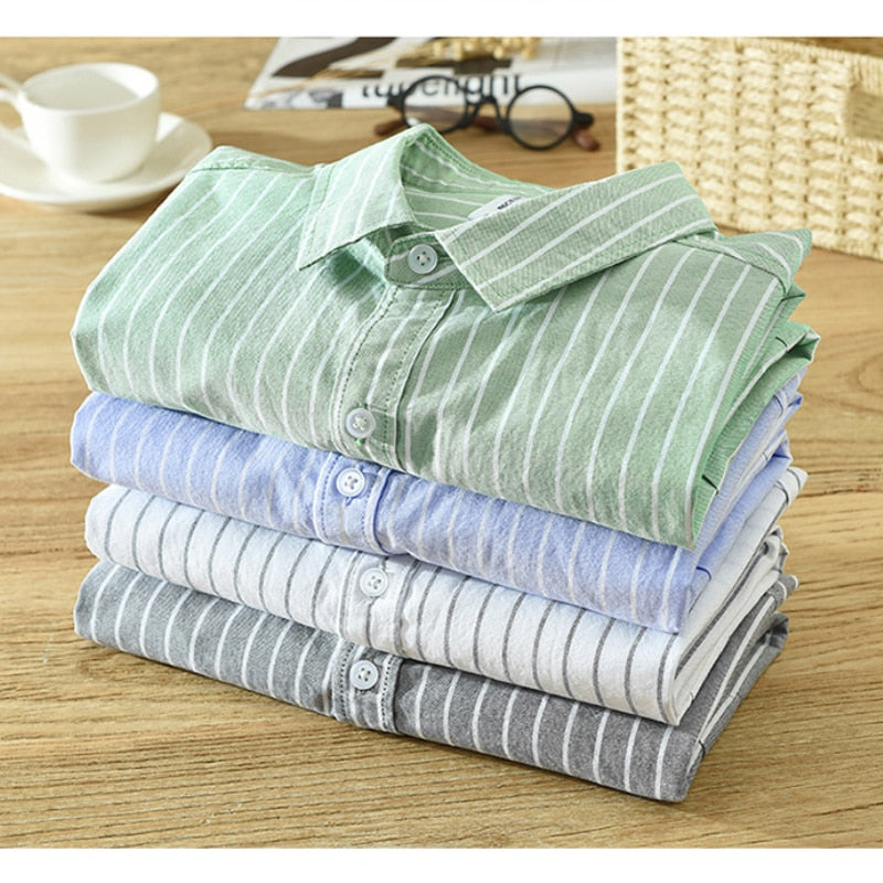 Antonios Green Striped Summer Shirt on a stack of folded shirts showcasing various colors.