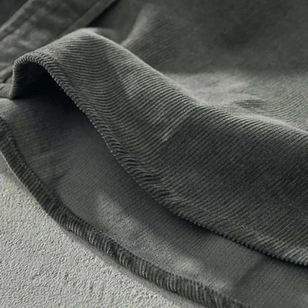 Close-up of green corduroy cargo spring shirt fabric, highlighting texture and quality.