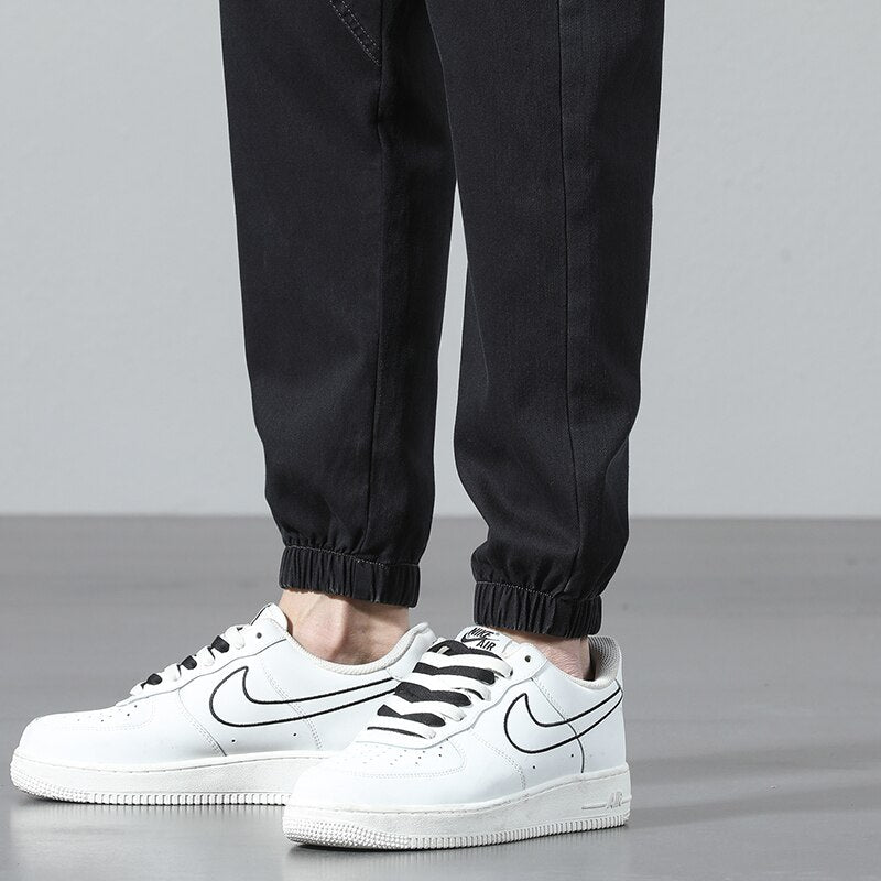 Men's Vinny Denim Joggers in black, relaxed fit, paired with sneakers.