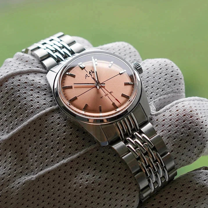 Vintage design watch with stainless steel case and band, pink dial, and buckle clasp, perfect for adding sophistication to casual or formal outfits.