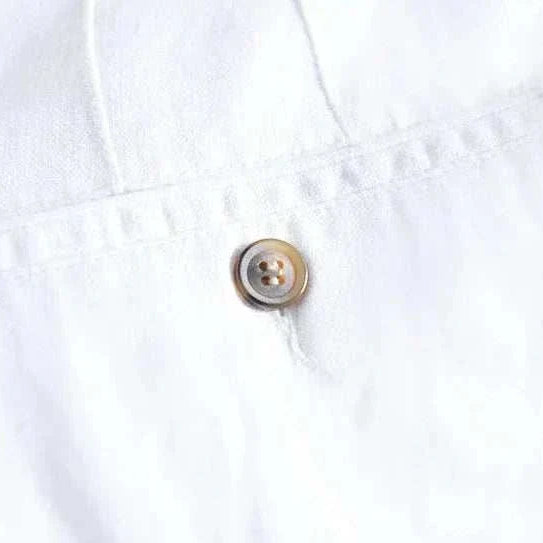 White straight oversize trousers with button detail.
