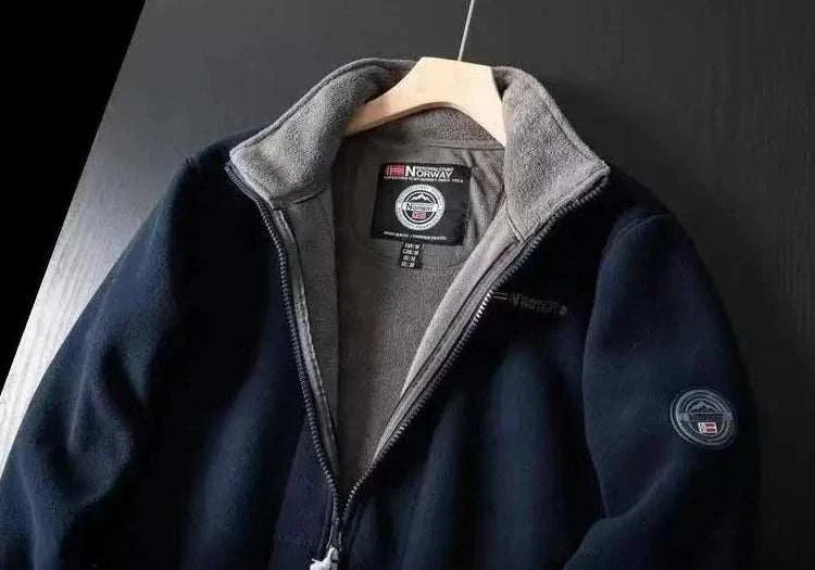 Norway puffer jacket in navy, lightweight and warm, hanging on a wooden hanger.