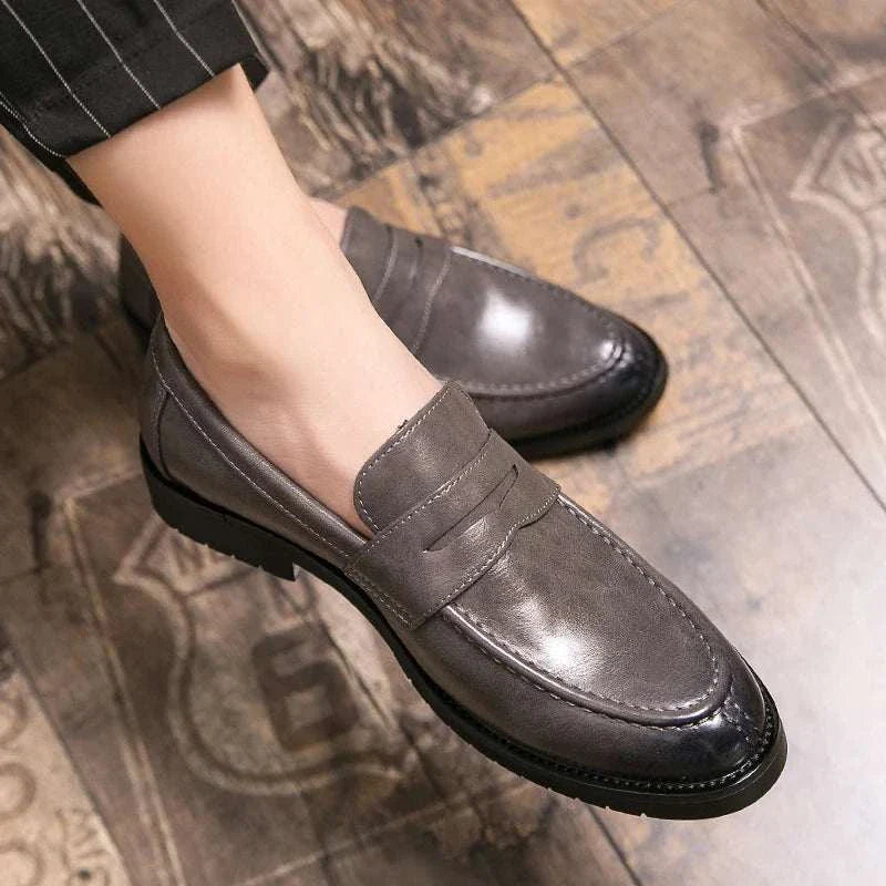 British casual loafers with rubber outsole on wooden floor.