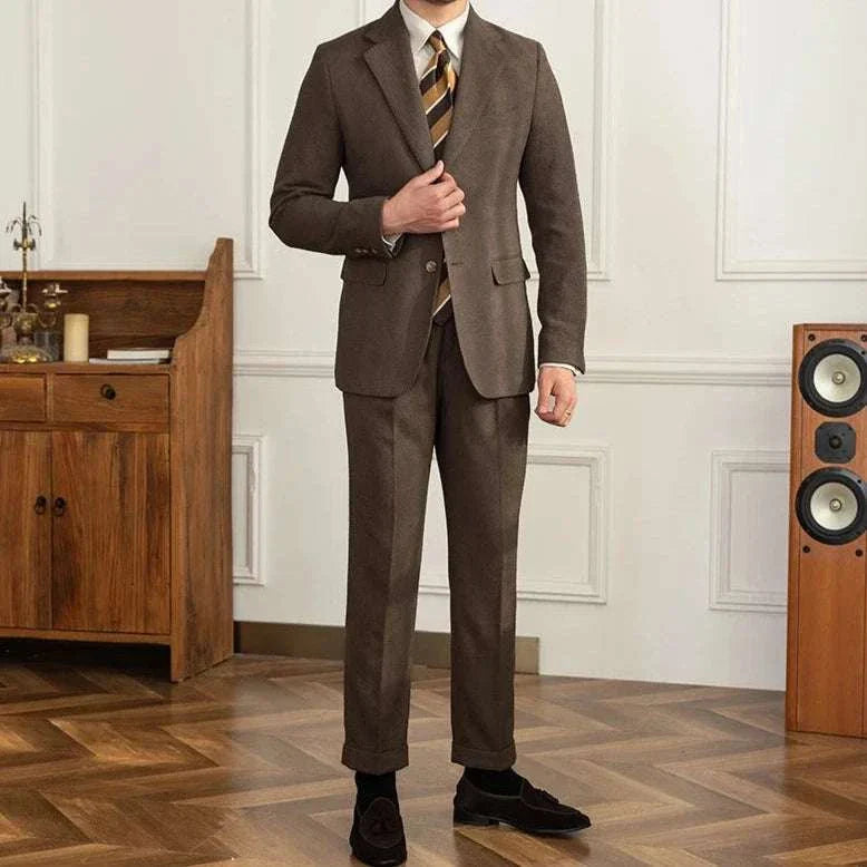 Elegant brown two-piece wedding suit with a tailored fit, worn with a striped tie, showcased in a stylish interior setting.
