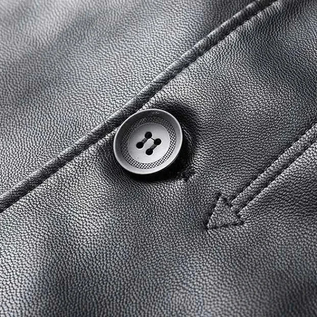 Close-up of a black PU leather long coat with button detail.
