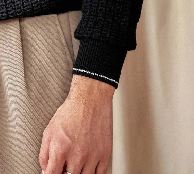 Close-up of a black winter wool sweater sleeve on a person.