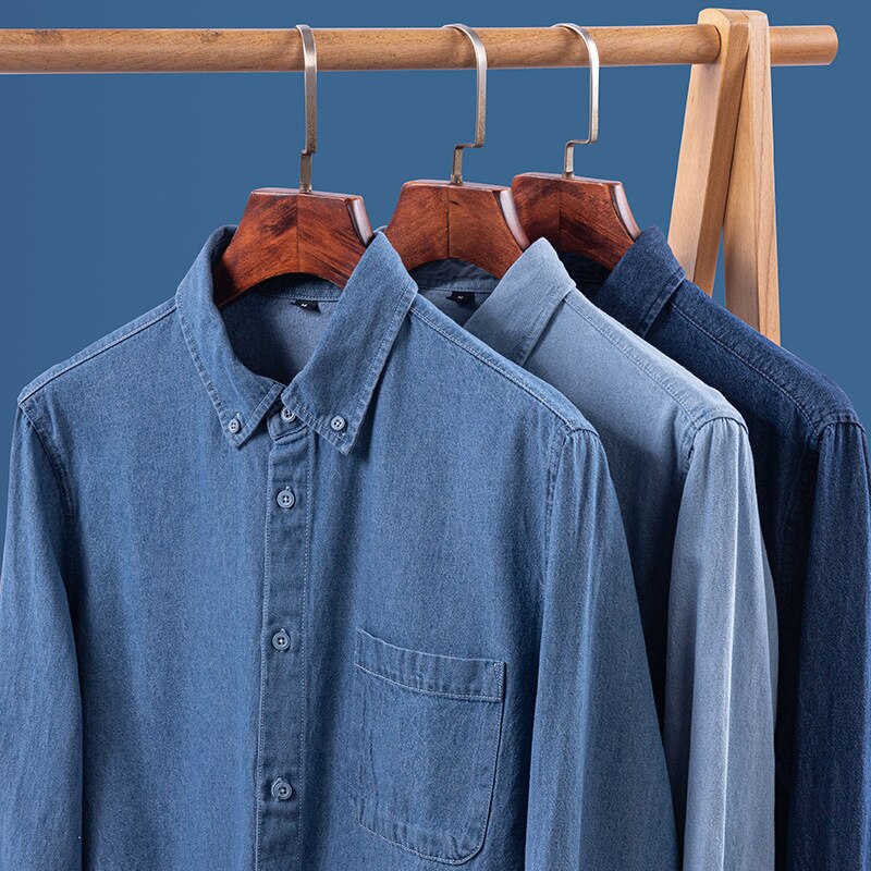 Business casual denim shirts on hangers in various shades, crafted from organic cotton with classic collars.