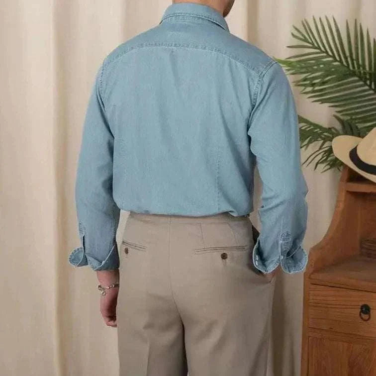 Back view of a man wearing a vintage casual long sleeve shirt in blue, paired with beige trousers.