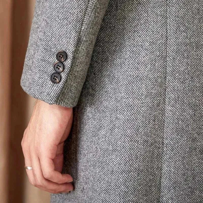 Close-up of a gray winter double-breasted wool coat sleeve with buttons.