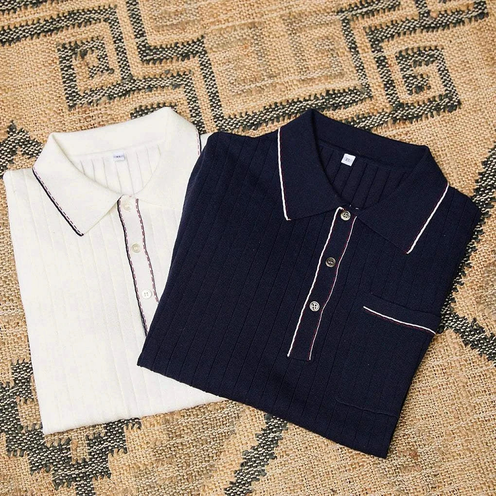 Two folded Old Money polo English t-shirts in white and navy on a patterned surface.