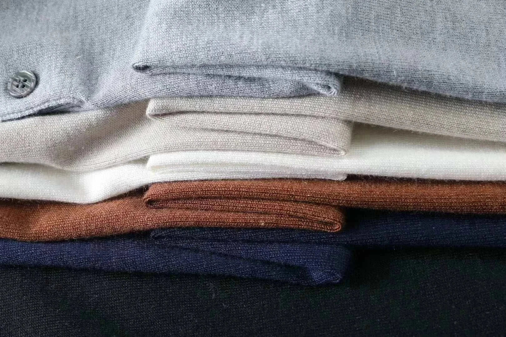 Folded autumn Korean premium sweaters with buttons in assorted colors.