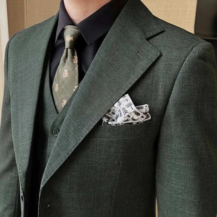 Groom wedding 3 piece suit in dark green with floral tie and pocket square.