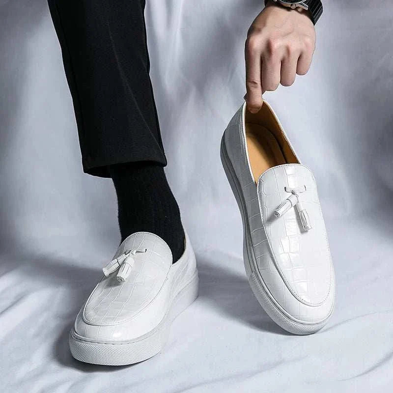 White casual slip-on loafers for men with tassel detail.