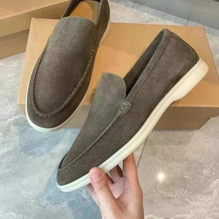 Suede elegant loafers made from soft sheep leather on a shoe box.