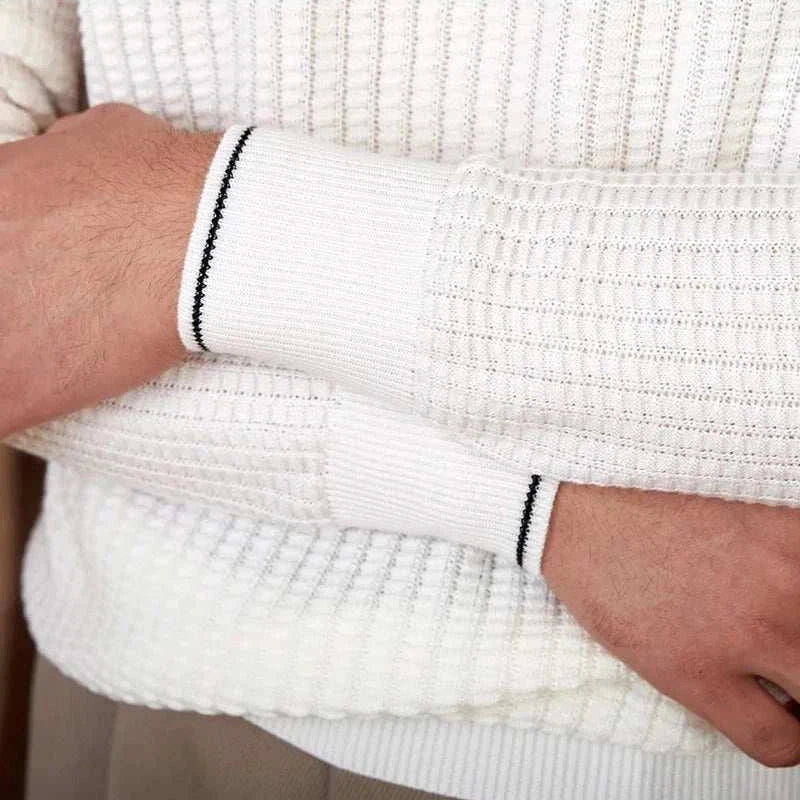 Close-up of knitted white winter wool sweater with ribbed cuffs.