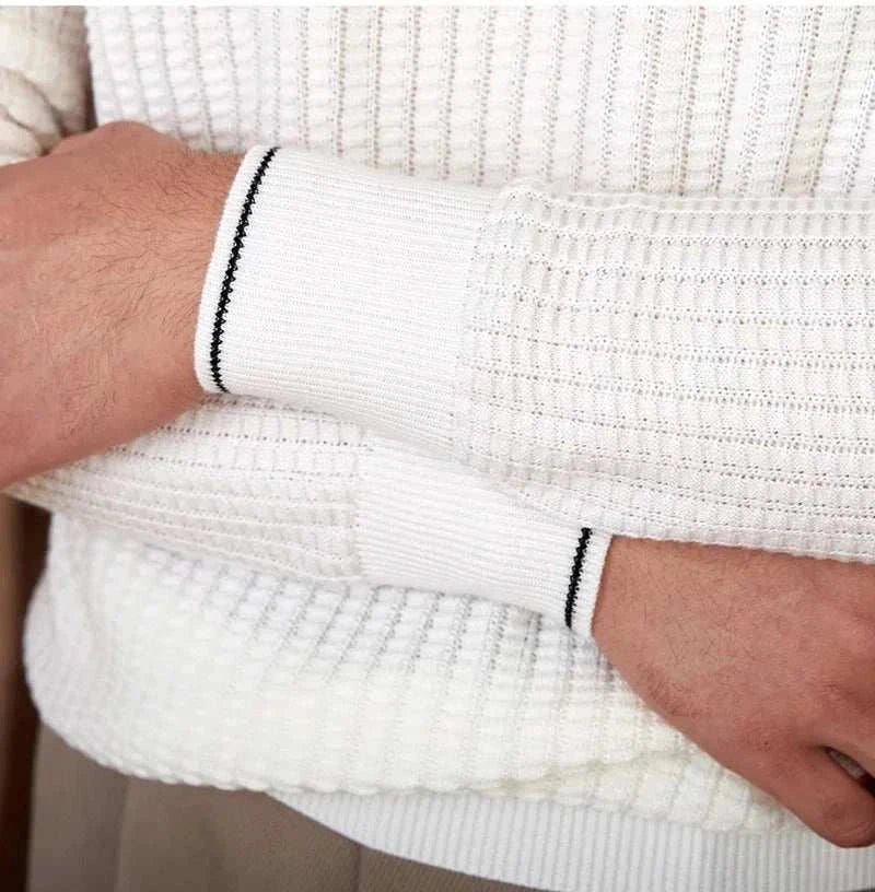 Close-up of knitted white winter wool sweater with ribbed cuffs.