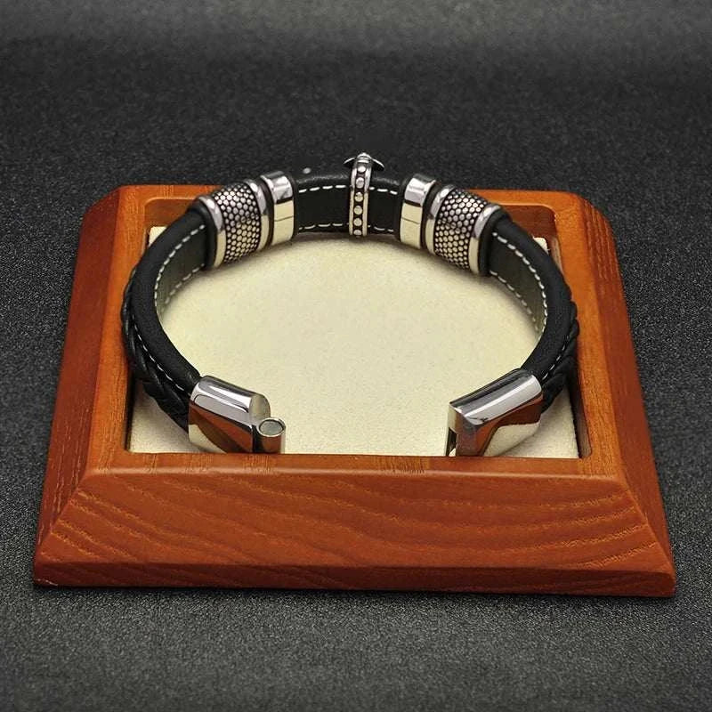 Cross punk leather bracelet with stainless steel accents on display.