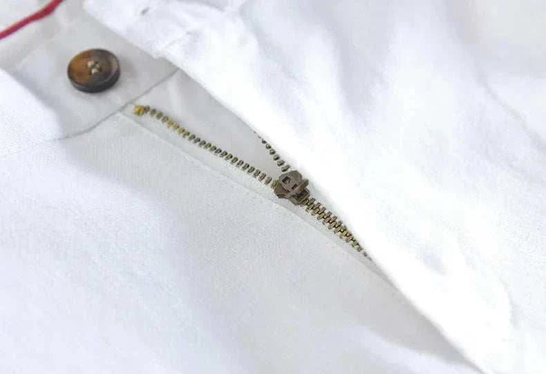 Close-up view of straight oversize trousers zipper and button detail in white polyester.