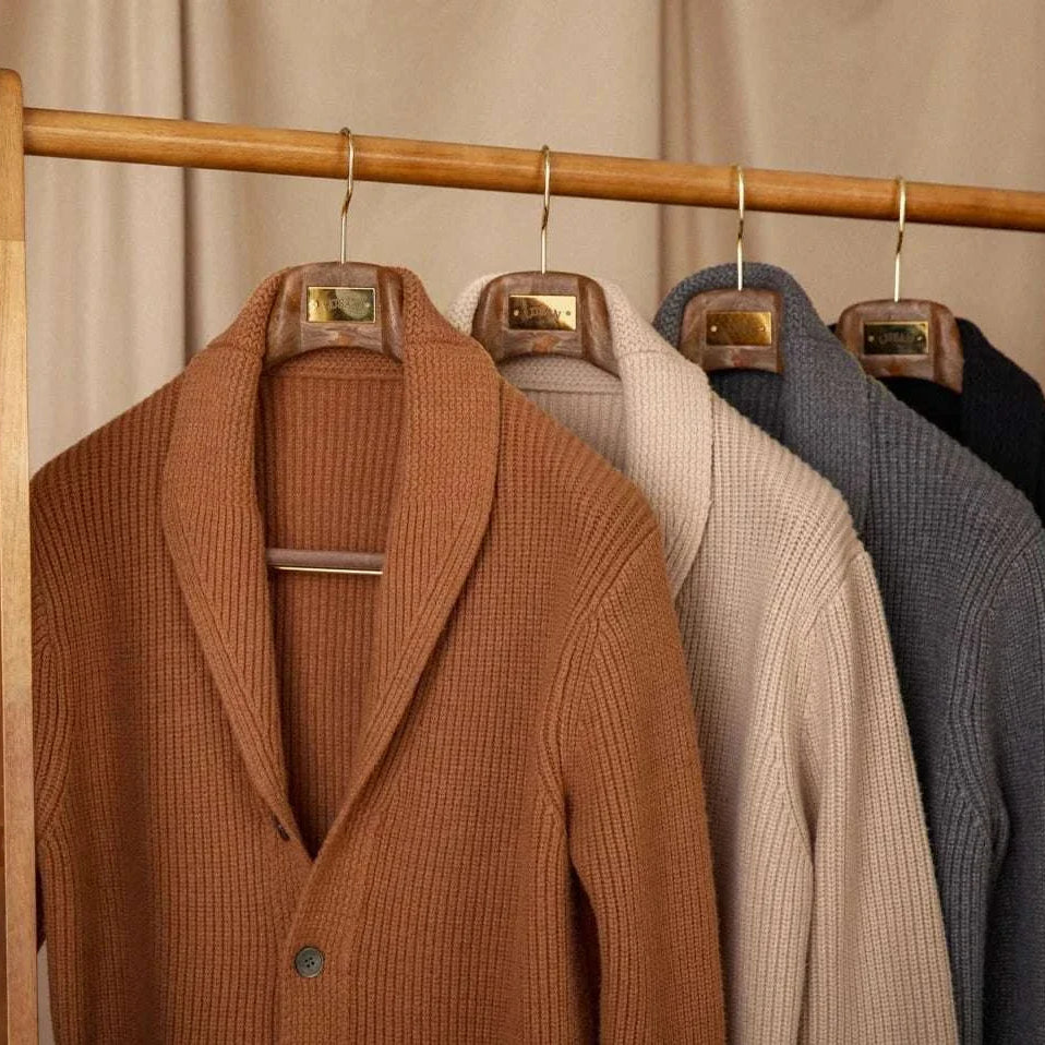 Autumn old money cardigan collection displayed on wooden hangers.