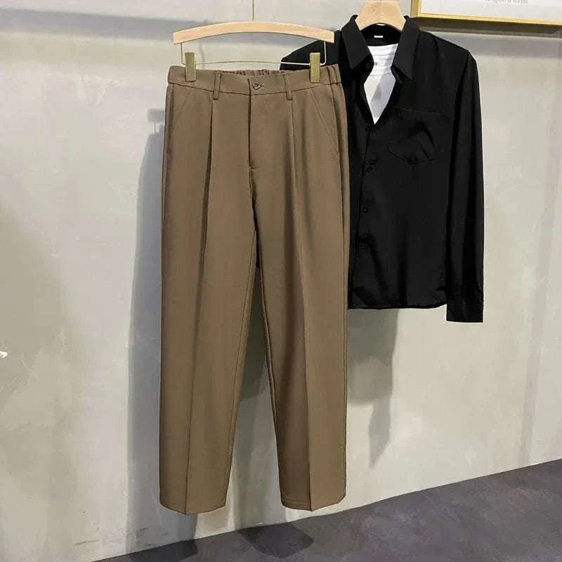 Korean chino pants made from 100% polyester in a casual and elegant style, displayed hanging beside a black shirt.