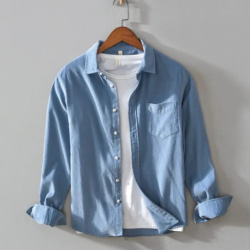 Casual cotton long sleeve shirt with pocket in blue stripes hanging on hanger.
