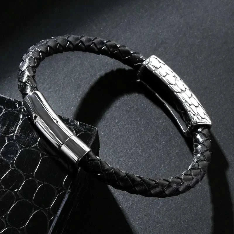 Genuine leather braided bracelet with stainless steel clasp on black surface.