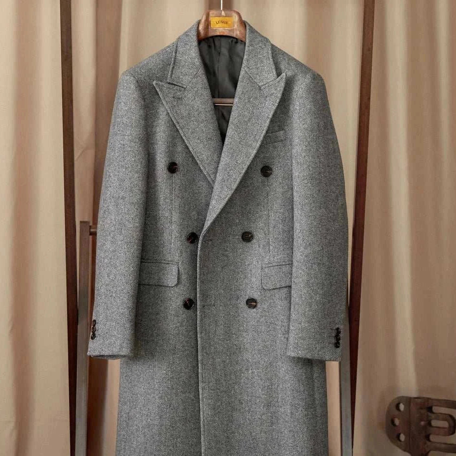 Men's winter double-breasted wool coat in gray, hanging on a wooden hanger.