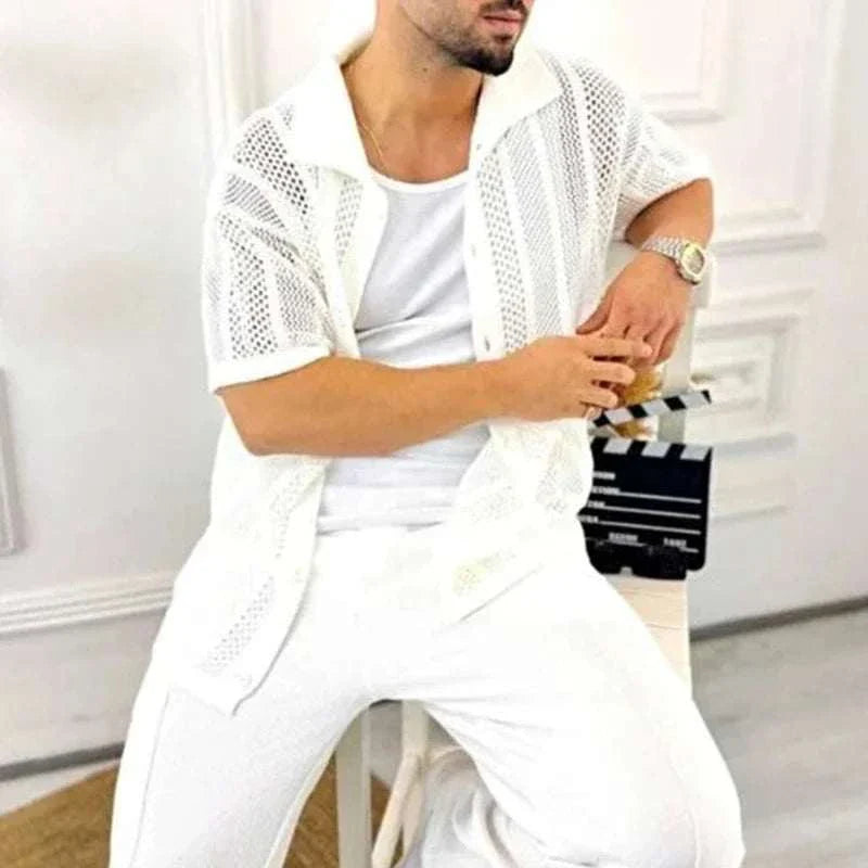 Man wearing a vintage casual short sleeve shirt in white, seated indoors.