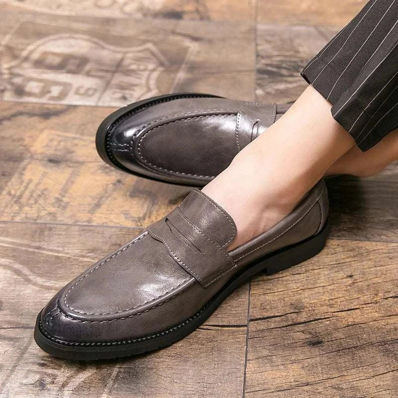 British casual loafers with rubber outsole on wooden floor.
