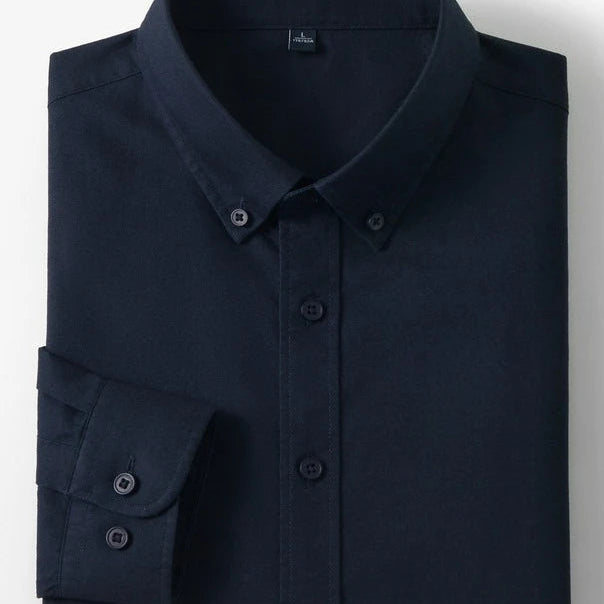 A folded dark navy long-sleeve button-down shirt with a pointed collar and button cuffs, shown on a light gray background with two small inset images on the right showing cotton and a fabric close-up.
