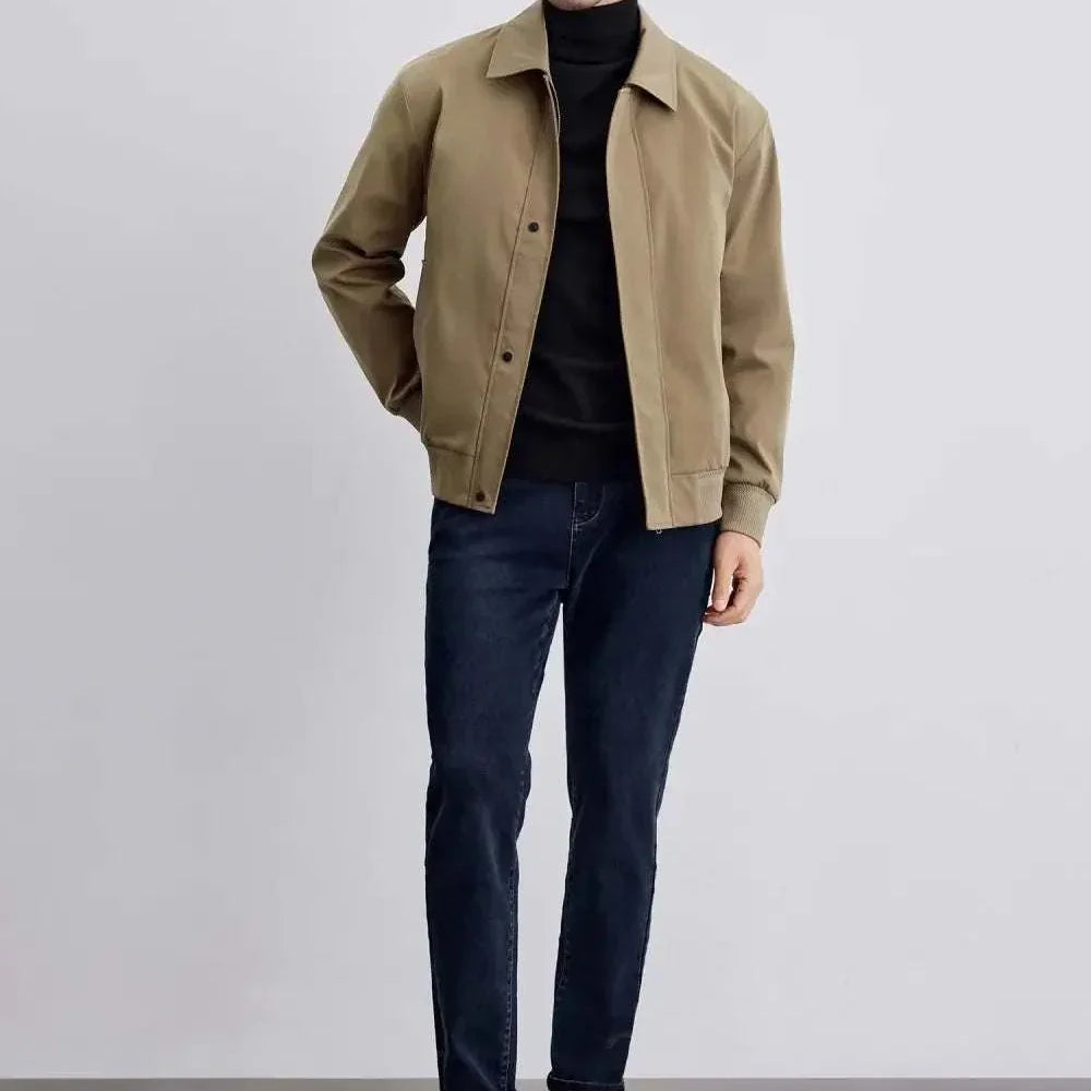 Man wearing Korean bomber winter jacket with black turtleneck and jeans.