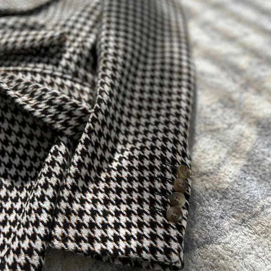 Houndstooth woolen retro suit blazer detail with classic plaid pattern and buttons.