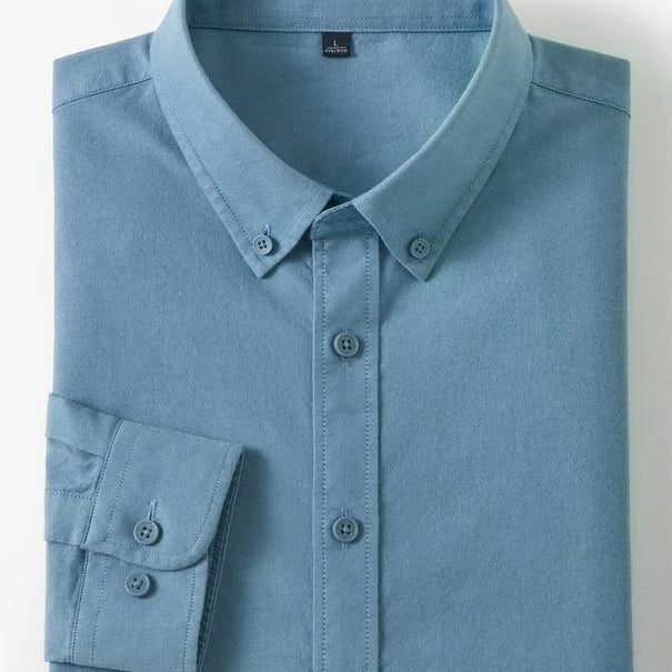 A folded light blue long-sleeve button-down shirt with a button collar and button cuffs, shown on a white background with two small inset images on the right showing cotton and fabric texture.