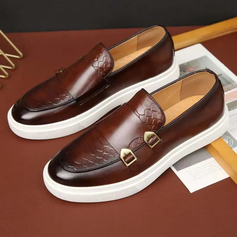 Retro British loafers in brown leather with buckle detail on a white sole.