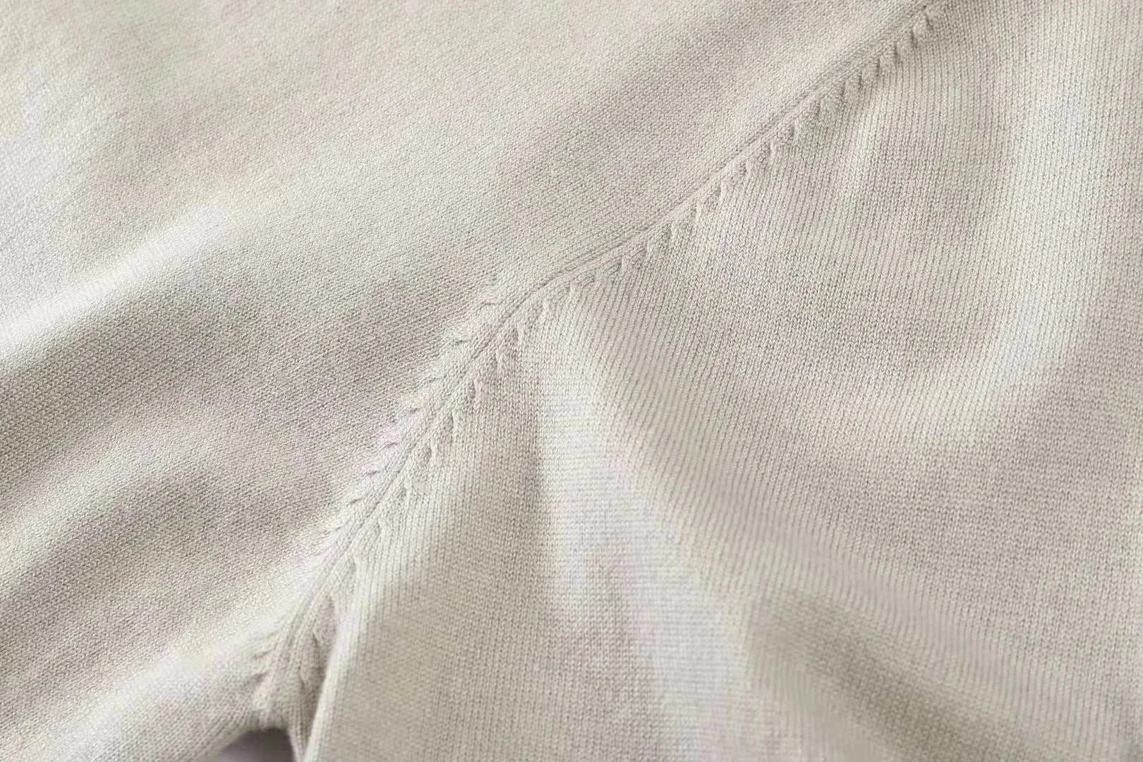 Close-up of fabric detail of an autumn Korean premium sweater with buttons, showcasing fine stitching and wool texture.