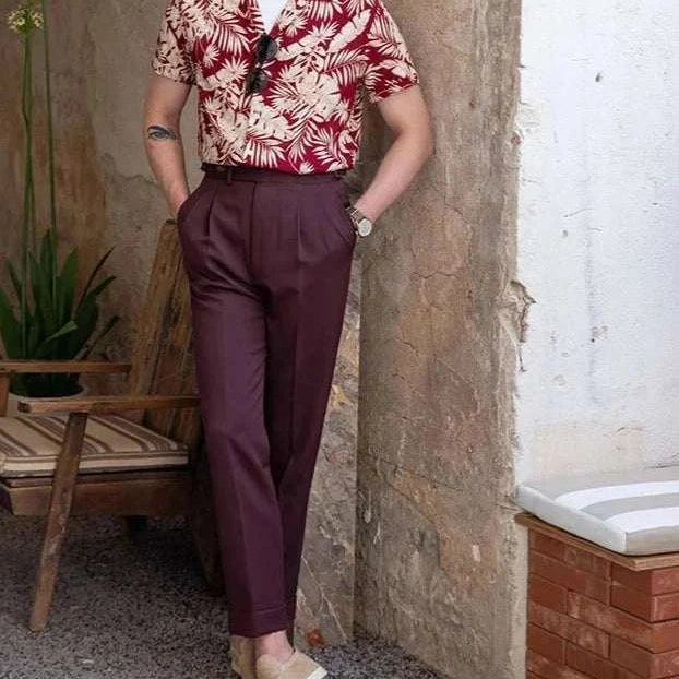 Vintage Hawaiian flower shirt with tropical design, worn by a man, styled casually with burgundy pants, perfect for summer/spring.