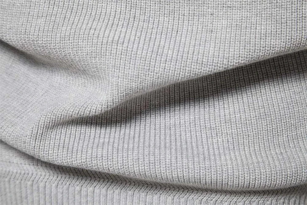 High-collar autumn/winter sweater fabric close-up showcasing ribbed knit texture in grey.