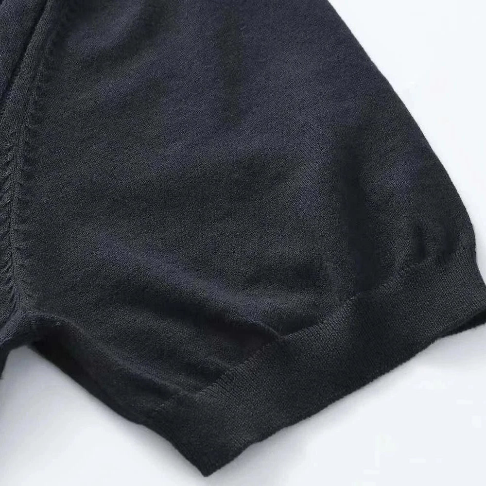 Close-up of a black cotton summer t-shirt sleeve with a classic ribbed texture, showing craftsmanship and material quality.