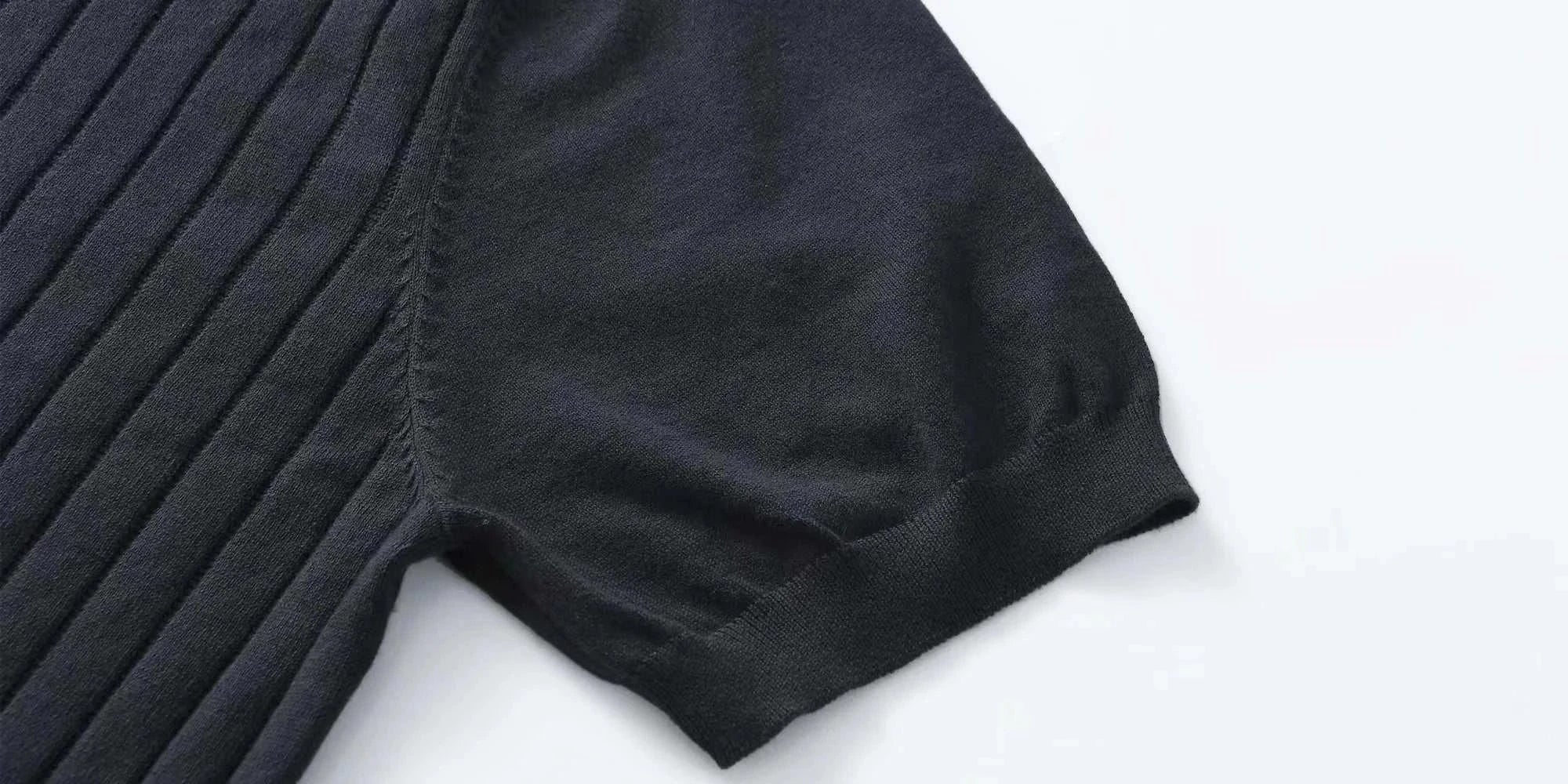 Close-up of a black cotton summer t-shirt sleeve with a classic ribbed texture, showing craftsmanship and material quality.