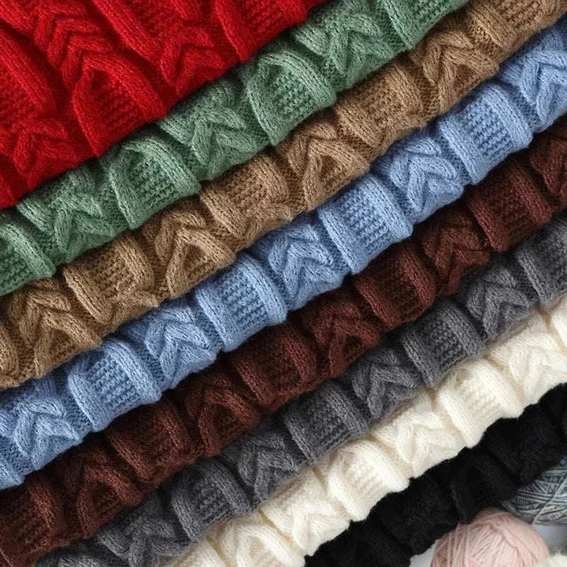 Juku winter sweater in various colors stacked neatly, showcasing premium quality knit texture.