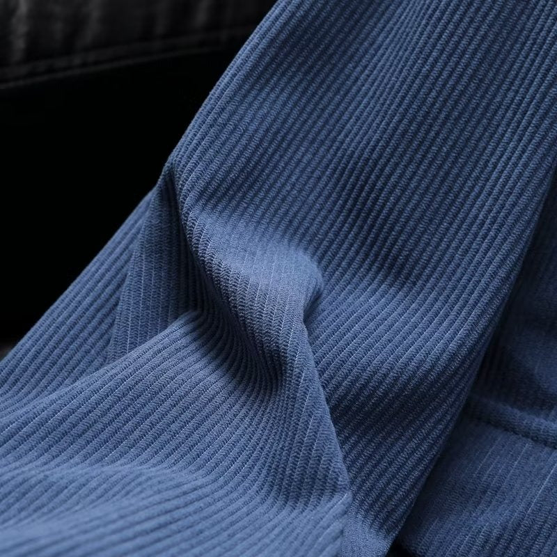 Blue corduroy fabric close-up of casual jacket, highlighting texture and design.