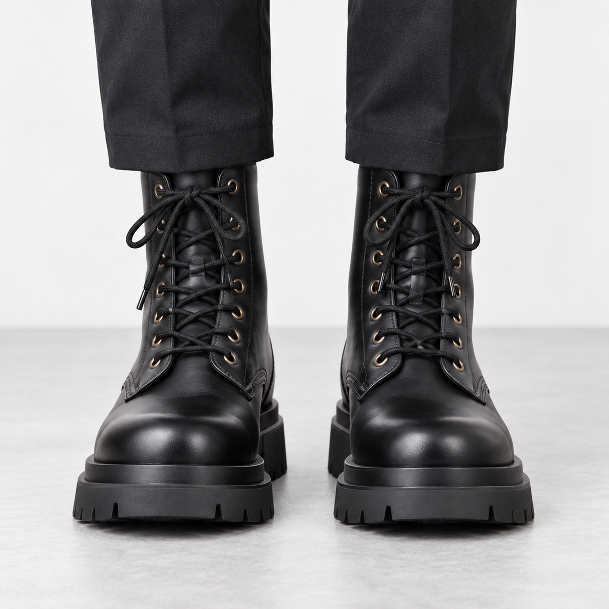 Black leather lace up combat boots in black, front view on a model