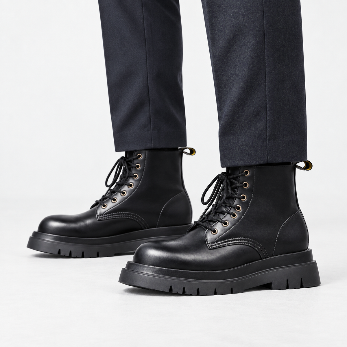 Black leather lace up combat boots in black, side view on a model