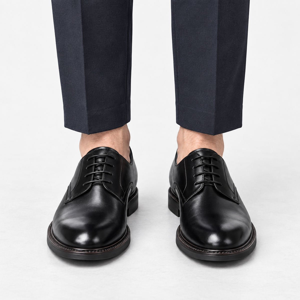 Leather plain toe derby shoes in black, front view on a model