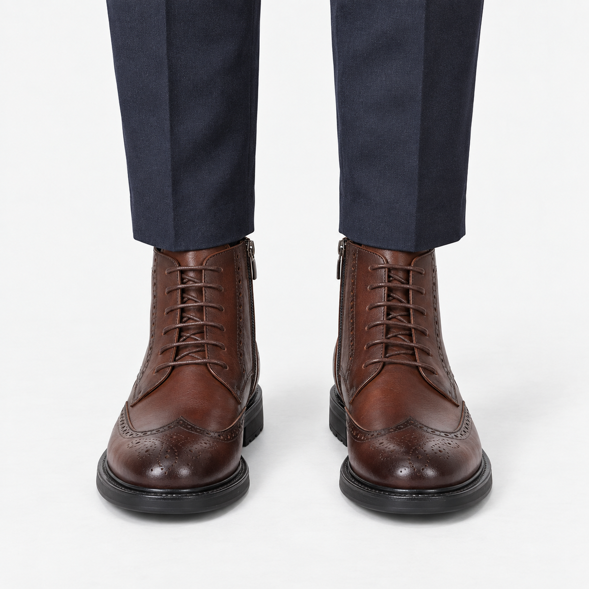 Leather wingtip boots with side zips in coffee, front view on a model