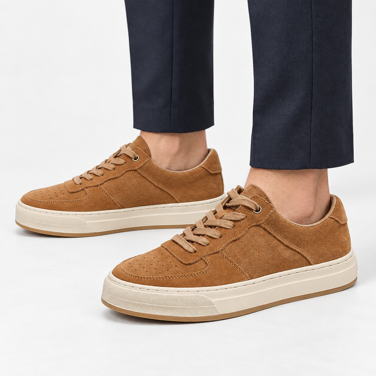 Suede panel low top sneakers in tan, side view on a model