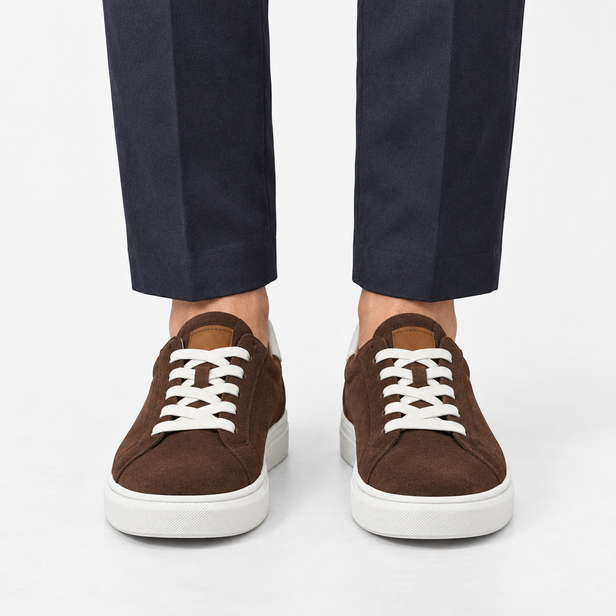 Suede sneakers with contrast heel tabs in brown, front view on a model