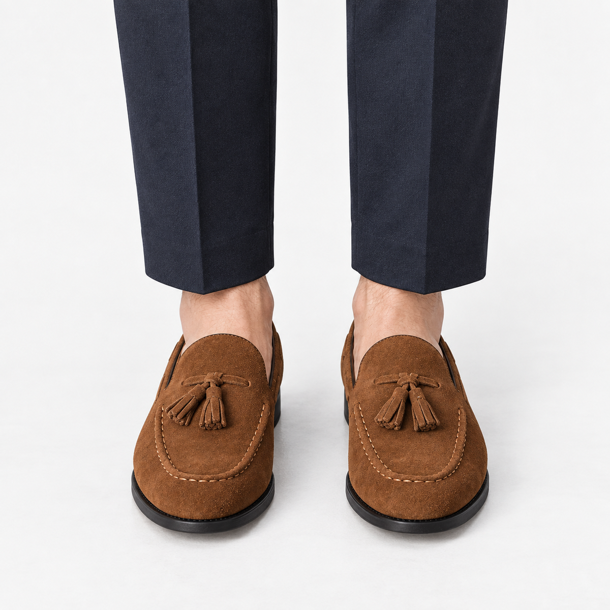 Suede tassel loafers with rubber soles in tan, front view on a model