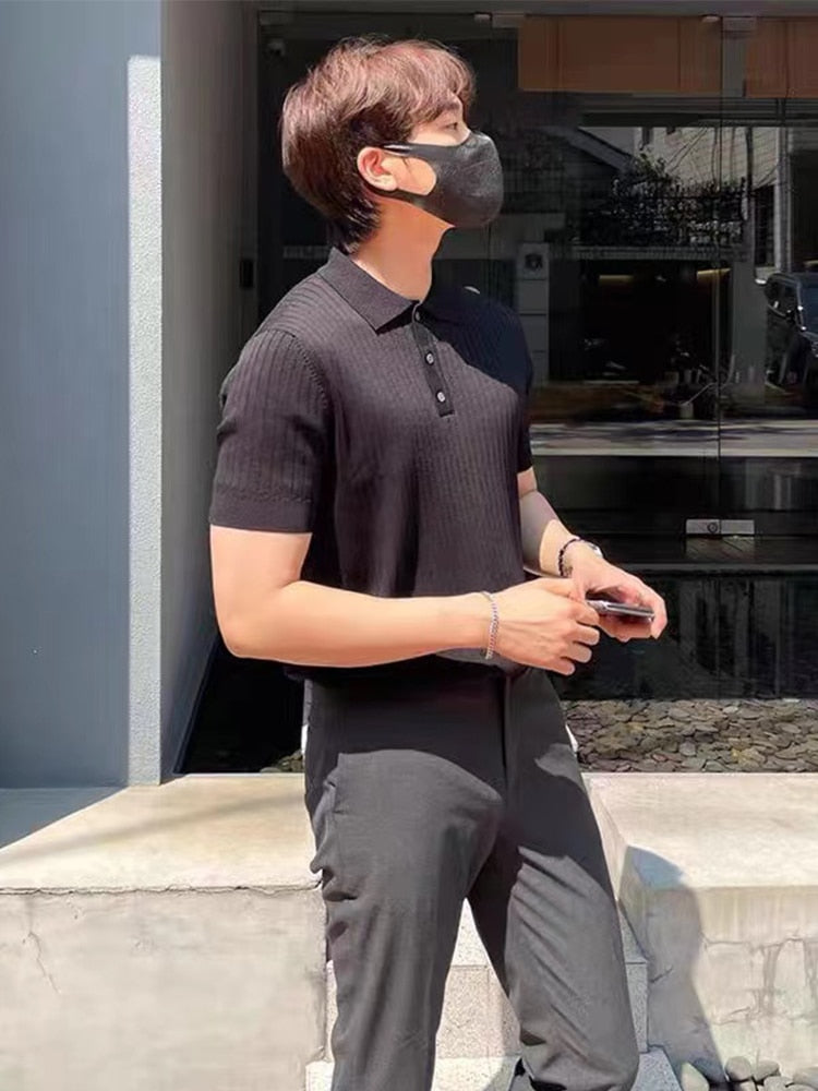 Man wearing AntoniosClothing Elastic Casual Polo T-Shirt in black, modern striped pattern, outdoors.